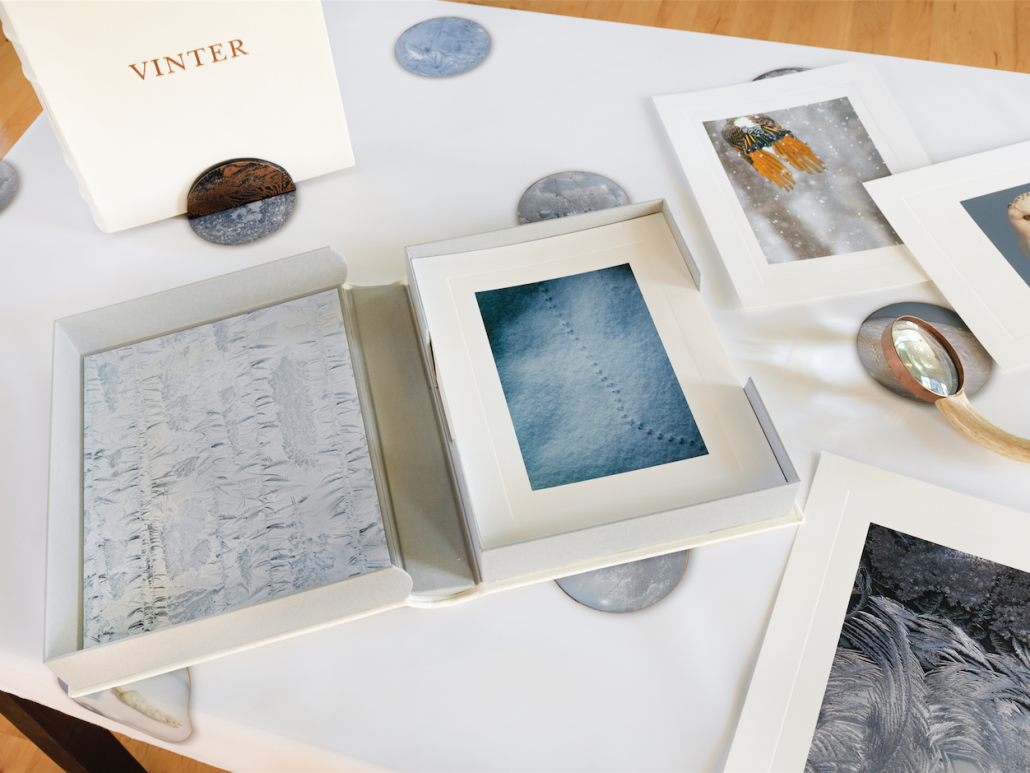 Vinter Clamshell Portfolio. Leather, pigmented ink fabric, book cloth. 9.5"w x 12"h x 2"d. 2015. Book stand. Copper, leather. 4"w x 2"h x 2.5"d. 2017. Vinter Tablecloth. Pigmented ink on satin. 44" x 84". 2017. Magnifying lens 2. Deer antler. 12"h x 2.75"w x 1"d. 2017. Embossed photographic prints. 8.5" x 11". 2017